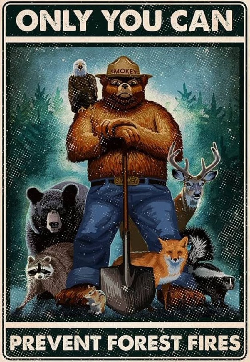 Vintage tin-sign poster of Smokey Bear with a shovel surrounded by forest animals